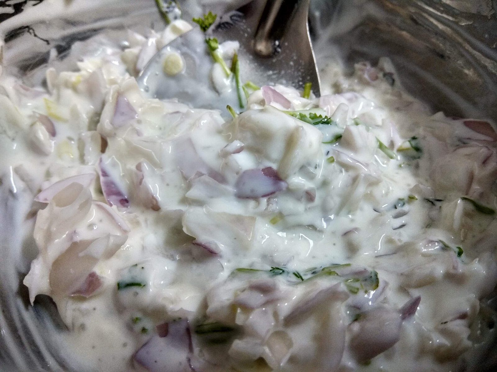 Raita med yoghurt, rødløg og krydderurter i en skål