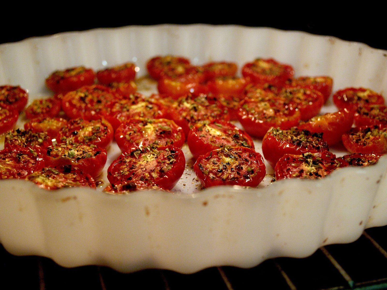 Semitørrede cherrytomater med oregano i et tærtefad i ovnen